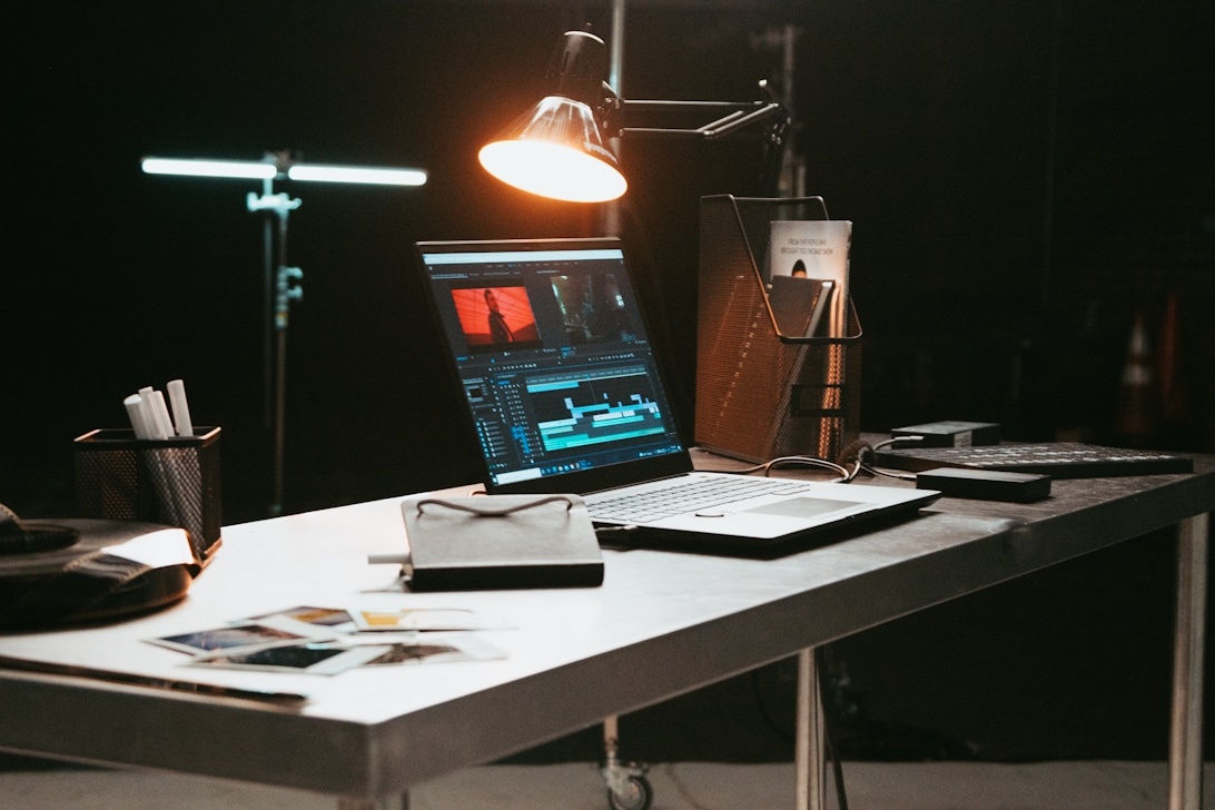 A modern creative workspace with a laptop displaying video editing software, symbolizing the digital tools artists use.
